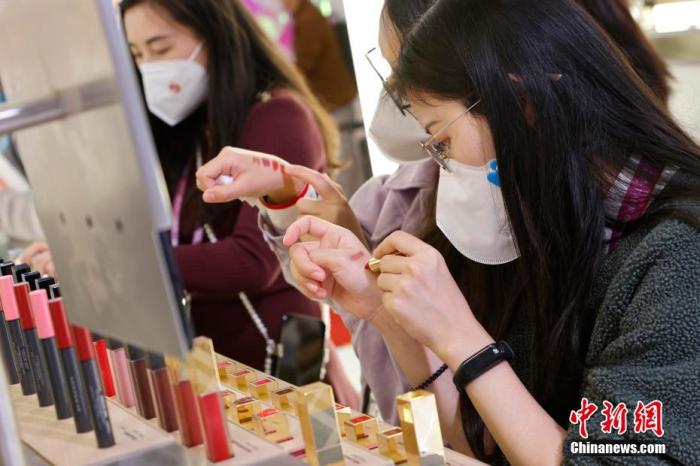圖為女生正在體驗口紅產(chǎn)品。 殷立勤 攝