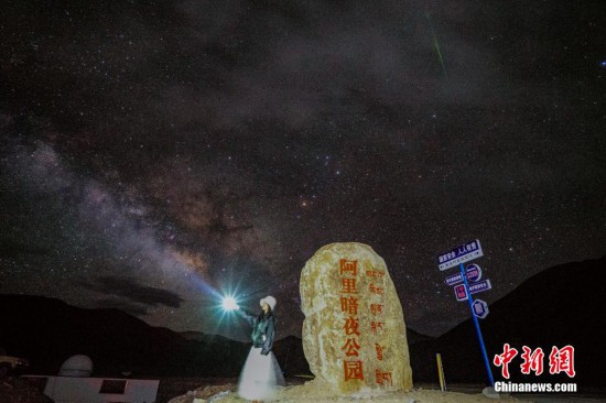圖為6月20日晚，游客“打卡”西藏阿里暗夜公園，天上是銀河與流星（右上角）。曹枝清 攝