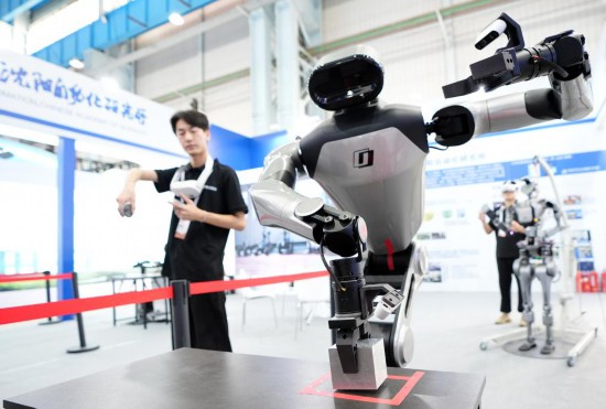 9月5日,在沈陽的2025全球工業(yè)互聯(lián)網(wǎng)大會的展覽區(qū)現(xiàn)場,中國科學院沈陽自動化研究所的機器人工程師在調(diào)試具身智能操作系統(tǒng)。新華社記者 李鋼 攝