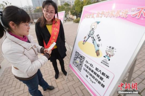 資料圖：今年3月8日，安徽合肥新華社區(qū)志愿者夏一瓊(右)向市民普及反家暴相關(guān)法律知識。鐘欣 攝