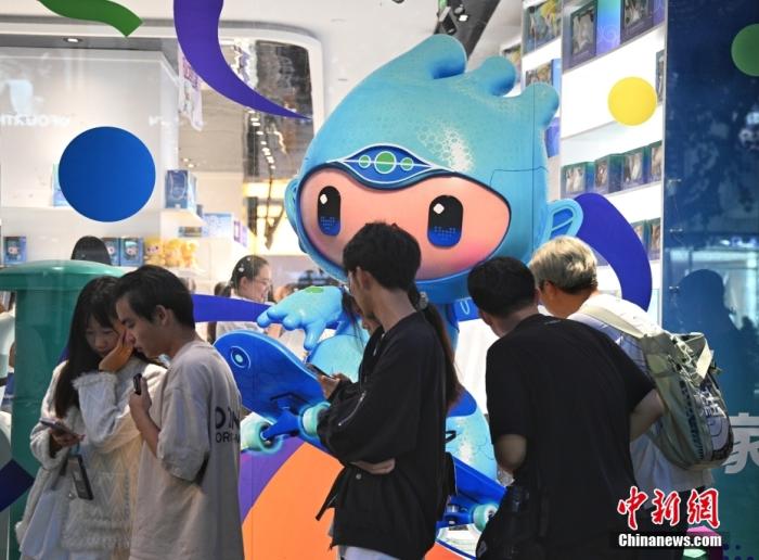 資料圖：9月23日，杭州第19屆亞運(yùn)會開幕式在浙江杭州奧體中心體育場舉行。圖為游人在亞運(yùn)特許商品店外排隊(duì)購物。<a target='_blank' href='/'>中新社</a>記者 王剛 攝
