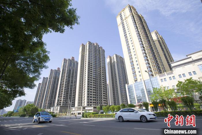 資料圖：車輛從一樓盤前經(jīng)過。 <a target='_blank' href='/'>中新社</a>記者 張?jiān)?攝