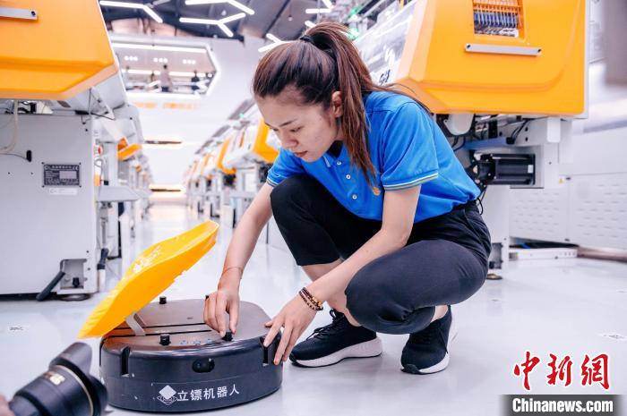 圖為員工在調(diào)試AGV搬運(yùn)機(jī)器人?！±钅宪?攝